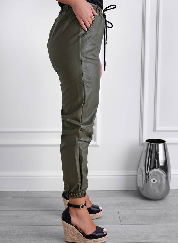 Green faux leather trousers with spring and drawstring at the waist