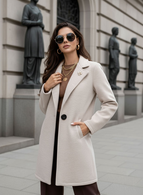 Cappotto beige con bottone nero e spilla
