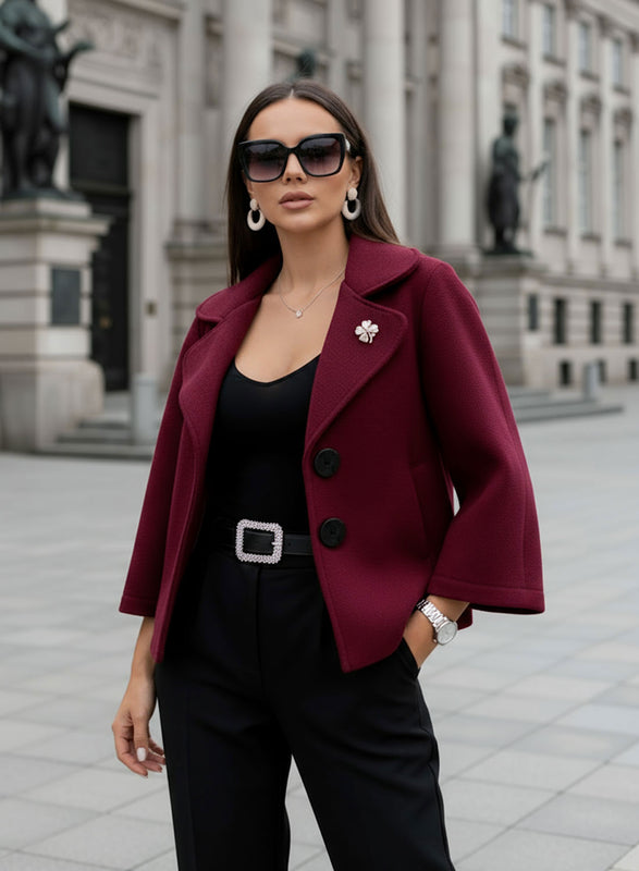 Short burgundy coat with black buttons and brooch