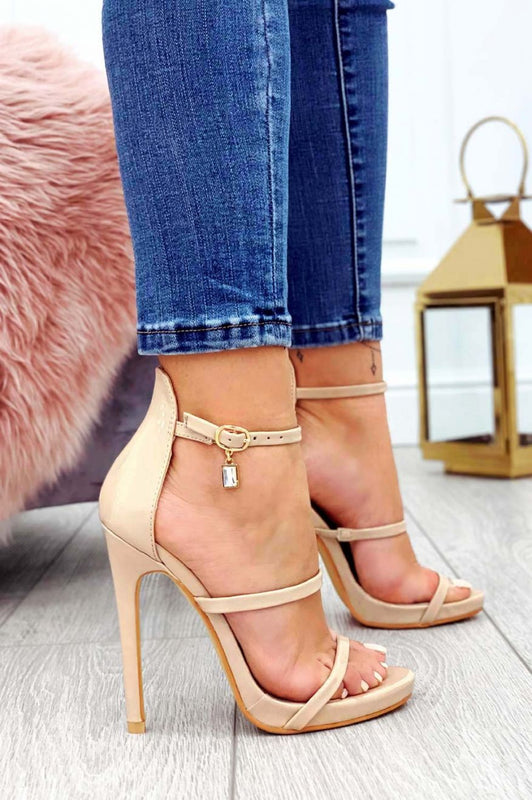 Sandales beiges en vernis à talons hauts avec pendentif bijou