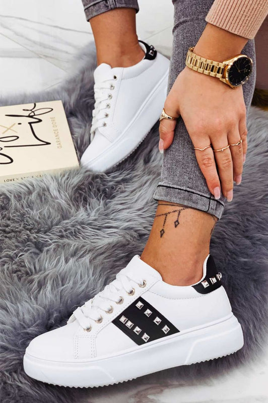 White sneakers with black inserts and studs