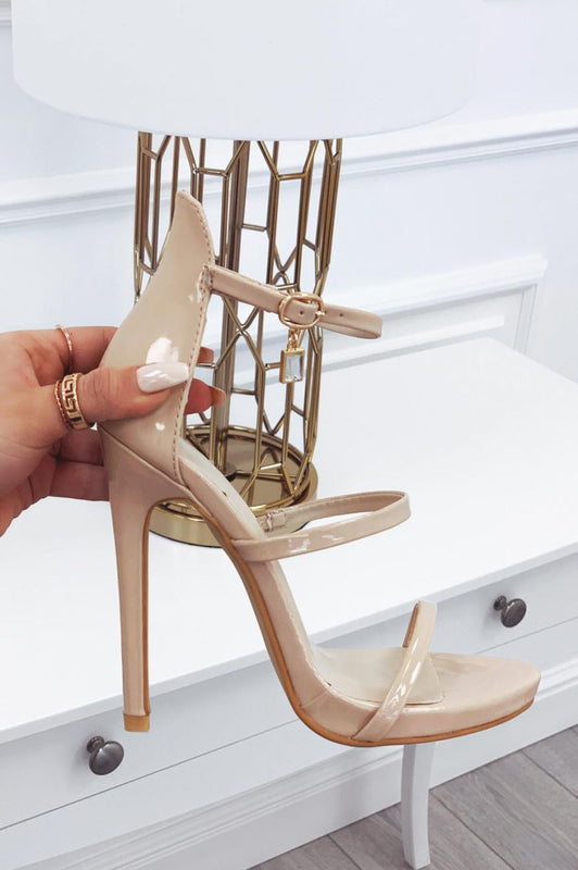 Sandales beiges en vernis à talons hauts avec pendentif bijou