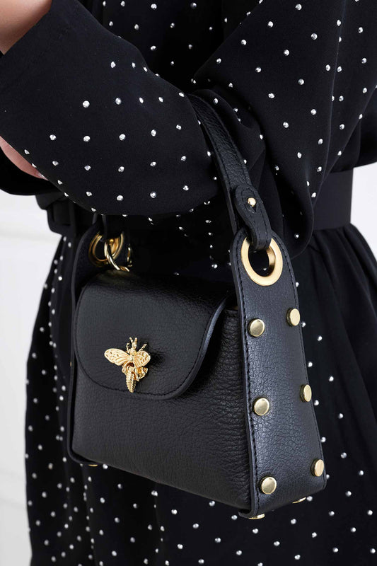 Black handbag with gold studs and removable shoulder strap
